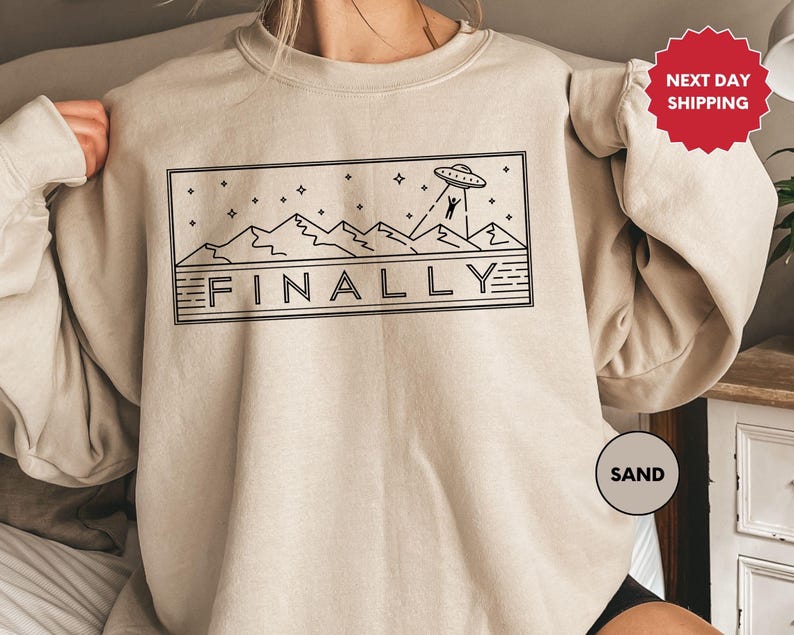 a woman wearing a sweatshirt with the word finaly printed on it