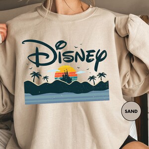 a woman wearing a sweatshirt with the disney logo on it