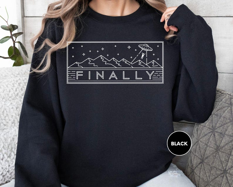 a woman wearing a black sweatshirt with the word finally printed on it
