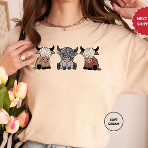 a woman wearing a t - shirt with three cows on it