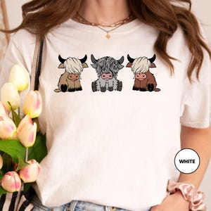 a woman wearing a t - shirt with three cows on it