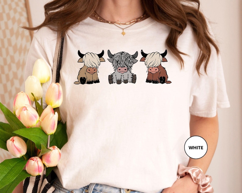 a woman wearing a t - shirt with three cows on it