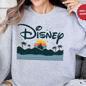a woman wearing a sweatshirt with the disney logo on it