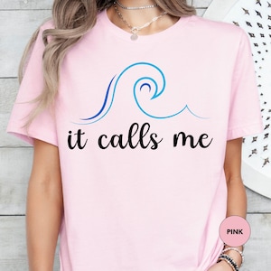 a woman wearing a pink shirt that says it calls me