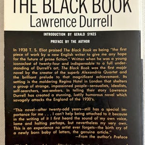 Puede incluir: Un libro de bolsillo titulado "The Black Book" de Lawrence Durrell. La portada presenta un logotipo rojo y blanco y texto en blanco y negro. La contraportada incluye texto sobre la novela y su autor.