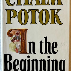May include: Book cover for "In the Beginning" by Chaim Potok. The title and author's name are in large, gold-colored letters. The cover features an illustration of two men, one wearing a yarmulke, reading at a table.