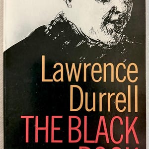 Puede incluir: Un libro de bolsillo vintage titulado "THE BLACK BOOK" de Lawrence Durrell. La portada es negra con el t&iacute;tulo en rojo y el nombre del autor en dorado. Una ilustraci&oacute;n en blanco y negro de un rostro masculino.