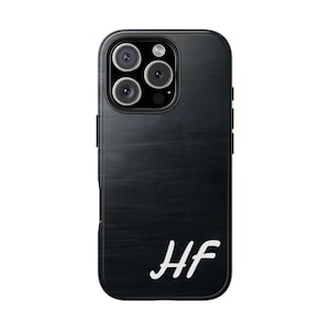 Könnte beinhalten: Schwarze Handyhülle mit Holzmaserung und den Initialen "HF" in Weiß.