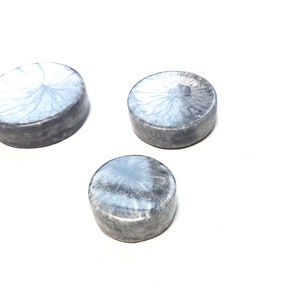 Può includere: Tre porta sapone rotondi, grigi e bianchi, decorativi con un design marmoreo.