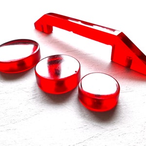 Peut inclure: Quatre pièces en plastique rouge pour un jeu ou un jouet. Trois sont rondes et une est une poignée incurvée.