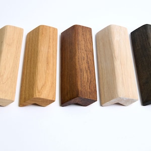 Peut inclure: Cinq pièces d'angle en bois dans différentes nuances de brun, du clair au foncé, y compris une pièce teintée de noir.