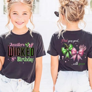 May include: Two images of a young girl wearing a dark gray t-shirt with the text "Jennifer's Wicked 8th Birthday" in green and pink. The back of the shirt says "Pink goes good... with green" with bows and a crown.