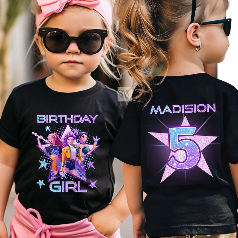 May include: Black t-shirt with a colorful graphic of three cartoon girls and the words "BIRTHDAY GIRL". The back of the shirt has the name "MADISION" and the number "5" inside a star.