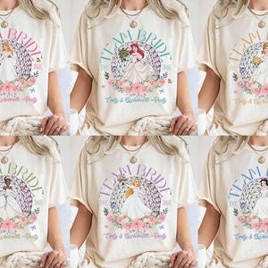 May include: Six white t-shirts with a floral design and the text "Team Bride" printed on the front. The design features a Disney princess in a white gown with a floral crown. The text "Est. 2023" and "Emily & Bachelorette Party" are also printed on the shirts.