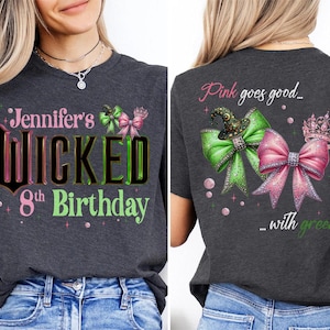 May include: Dark gray t-shirt with the text "Jennifer's Wicked 8th Birthday" in pink, green, and black. The back of the shirt features a green bow with a witch hat and a pink bow with a crown, with the text "Pink goes good... with green."