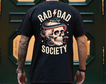 May include: Black t-shirt featuring a skull with a snake wrapped around it. The design includes the words "RAD DAD SOCIETY" in a stylized font, with a lightning bolt graphic. The shirt has a vintage, distressed look.