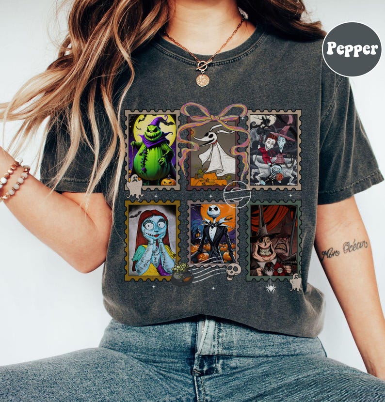 May include: Dark gray t-shirt featuring a collage of six postage stamp-style images of characters from The Nightmare Before Christmas. The images include Jack Skellington, Sally, and Oogie Boogie. The shirt has a vintage, worn look.