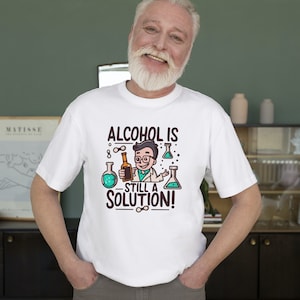 May include: White t-shirt with a cartoon scientist holding a bottle of alcohol. The text on the shirt reads "Alcohol is still a solution!"