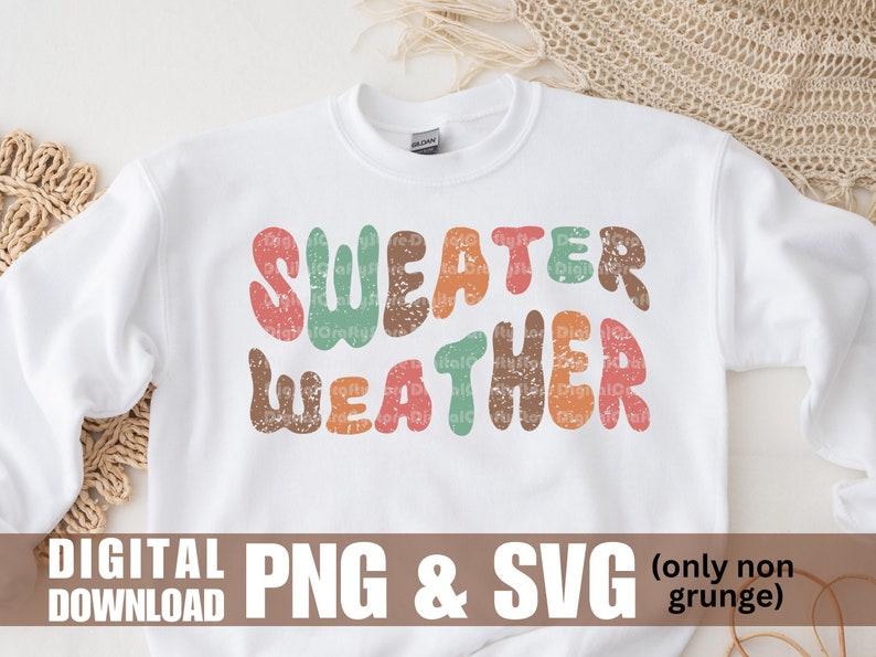 K&ouml;nnte beinhalten: Wei&szlig;er Pullover mit dem Text "SWEATER WEATHER" in bunten, abgenutzten Lettern im Retro-Stil.