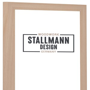 Könnte beinhalten: Ein heller Holzbildrahmen mit einem weißen Passepartout und einem schwarz-weißen Logo mit der Aufschrift "Woodwork Stallmann Design Germany".