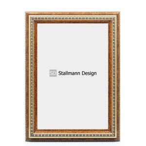 Może przedstawiać: Brązowa ramka do obrazu z ozdobną złotą ramką. Ramka ma białe tło i napis "SD Stallmann Design" w środku.