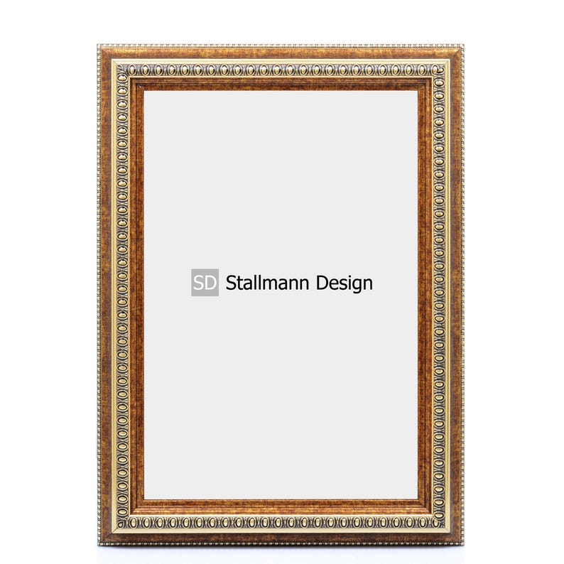 Może przedstawiać: Brązowa ramka do obrazu z ozdobną złotą ramką. Ramka ma białe tło i napis "SD Stallmann Design" w środku.