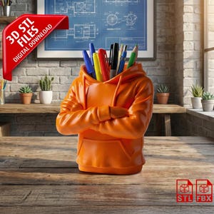 Peut inclure: Un organiseur de bureau en forme de sweat à capuche orange contenant des stylos et des crayons. L'organisateur est posé sur un bureau en bois, avec un mur de briques en arrière-plan. Une bannière rouge indique "3D STL FILES DIGITAL DOWNLOAD".
