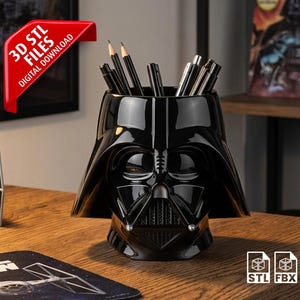 May include: Black Darth Vader head-shaped desk organizer filled with pens and pencils. The organizer is on a wooden desk, with a Star Wars mousepad and a model Tie Fighter nearby. A red banner reads "3D STL FILES DIGITAL DOWNLOAD".