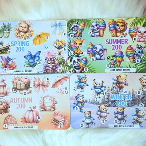 May include: Four illustrated cards with seasonal themes: Spring with flowers and a bear, Summer with animals and ice cream, Autumn with pumpkins, and Winter with bears in the snow. Each card has the text "AURA ROYALE DESIGNS".
