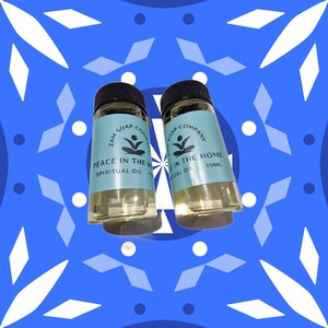 Può includere: Due piccole bottiglie di vetro trasparente con tappi neri. Le bottiglie contengono un liquido giallo chiaro. Le etichette sulle bottiglie riportano "Zam Soap Company" e "Peace in the Home Spiritual Oil" e "In the Home Ritual Oil 10ml".
