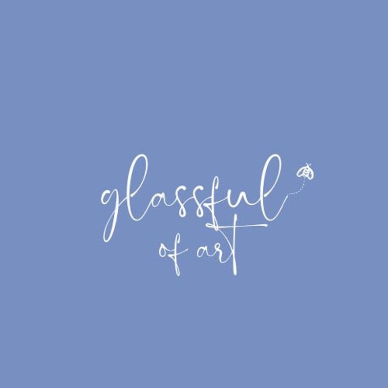 May include: White cursive text on a light blue background reads "glassful of art" with a small bee flying to the right of the text.