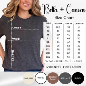 May include: A dark gray short-sleeve t-shirt shown with a Bella + Canvas size chart. The chart displays measurements in inches for sizes XS through 5XL, including width, chest, and length. Five color circles are shown below: natural, white, heather brown, asphalt, and black.