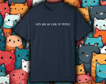 May include: A navy blue t-shirt with the text "Cats are my kind of people" printed in white on the front. The shirt is surrounded by a pattern of cartoon cats in various colors.