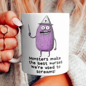 May include: White ceramic mug with a purple monster wearing a doctor's hat and holding a syringe. The text on the mug reads "Monsters make the best nurses we're used to screams!"