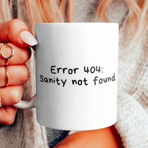 Op de afbeelding: Een witte keramische mok met zwarte tekst die "Fout 404: Geestelijke gezondheid niet gevonden" zegt.