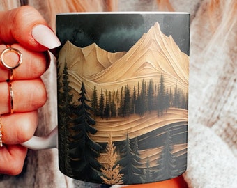 May include: White ceramic mug with a mountain and forest landscape design in gold, brown, and dark green. The mug has a black sky background with stars. The mug is held by a person.