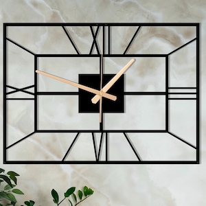 Puede incluir: Reloj de metal negro con marco y números romanos y manecillas doradas.