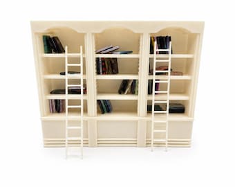 Könnte beinhalten: Ein cremefarbenes Miniatur-Bücherregal mit drei vertikalen Abschnitten und gewölbten Oberseiten. Das Regal enthält mehrere Fächer mit kleinen, verschiedenfarbigen Büchern. Zwei hohe, schmale, cremefarbene Leitern sind an der Vorderseite angebracht.