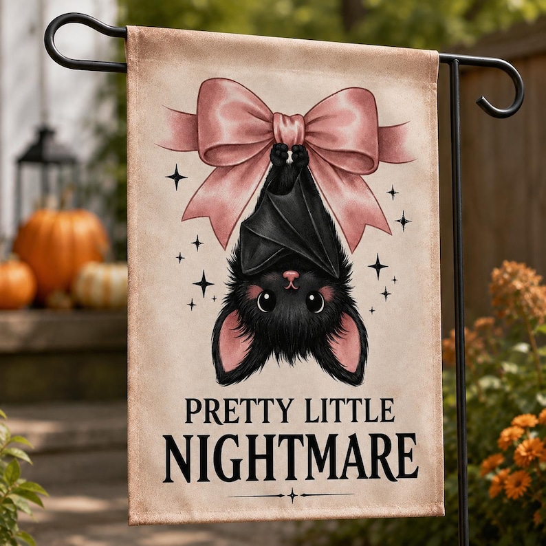 May include: A rectangular garden flag featuring a black bat hanging upside down from a large pink bow. The background is a light beige color with small black star accents. The text "PRETTY LITTLE NIGHTMARE" is printed in black at the bottom.