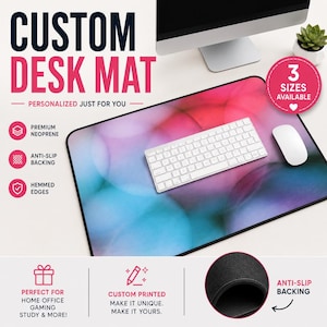 Può includere: Tappetino per scrivania personalizzato con un vivace design astratto in rosa, blu e bianco. Una tastiera e un mouse bianchi sono sul tappetino. Il testo sul tappetino recita "CUSTOM DESK MAT" e "PERSONALIZED JUST FOR YOU". Ha un retro antiscivolo e bordi orlati.