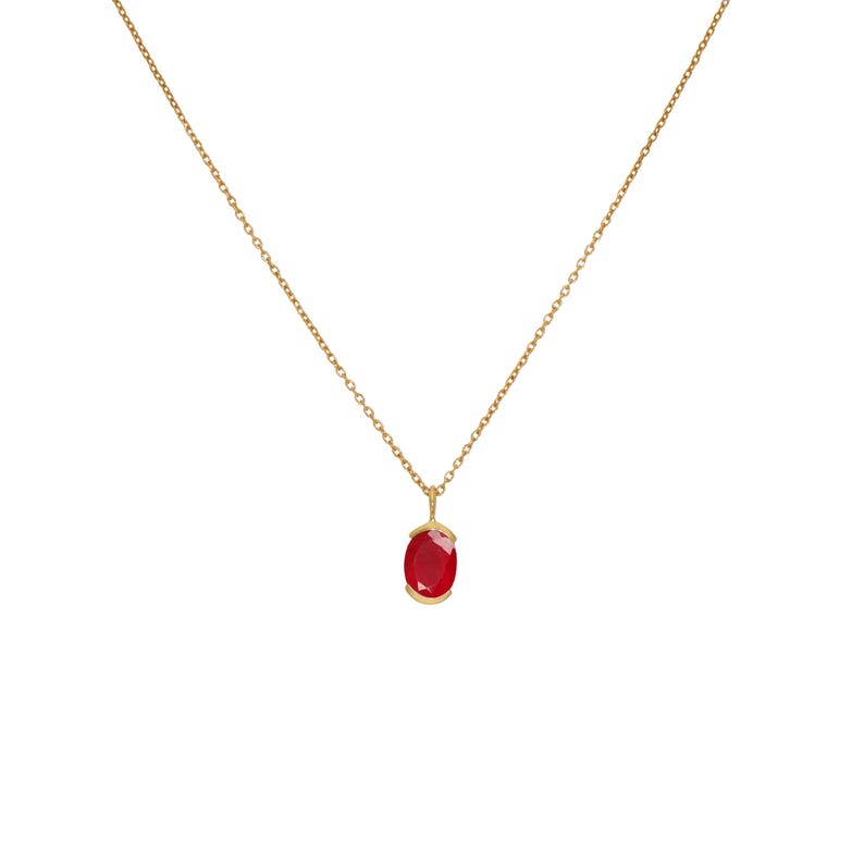 May include: A gold chain necklace with a red oval gemstone pendant.