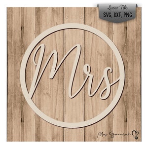 Könnte beinhalten: Ein weißer Kreis mit dem Wort "mrs" in Kursivschrift auf einem Holzmaserungshintergrund.