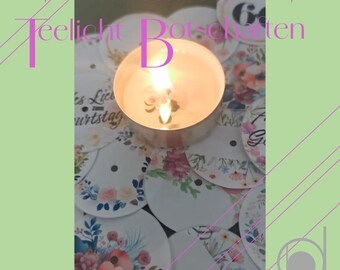 May include: A lit tea light candle sits on a pile of round white paper circles with floral designs. The circles have the text "60. Geburtstag" and "Teelicht Botschaften" printed on them.