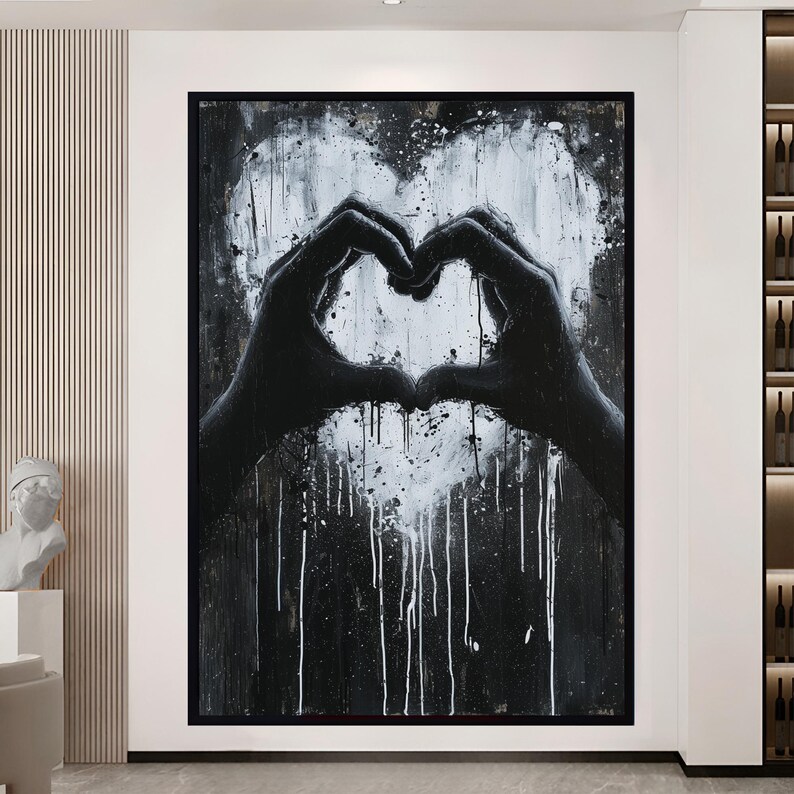 May include: Black and white abstract painting of two hands forming a heart shape. The background is a dark gray with white paint splatters.