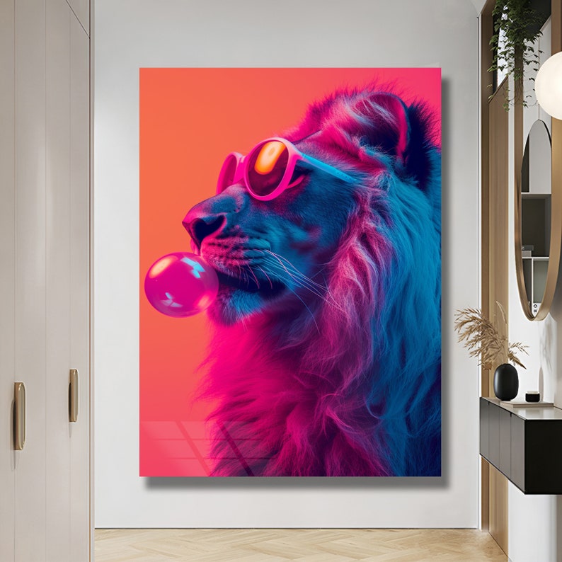 May include: A rectangular wall art print featuring a profile view of a lion wearing bright pink sunglasses and blowing a large, round, glossy pink bubblegum bubble. The lion is rendered in vibrant neon shades of blue, purple, and hot pink against a solid orange background.