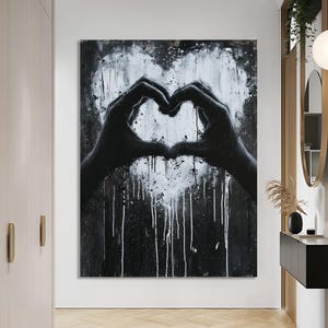 May include: Black and white abstract painting of two hands forming a heart shape. The heart is outlined in white paint and has a dripping effect.