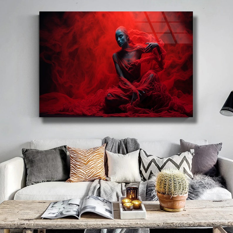 May include: A woman with blue skin sits in a red, flowing fabric. The fabric is draped around her and billows out behind her. The background is a dark red with a hazy, smoky effect.