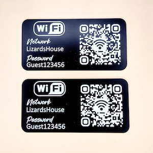 May include: Two black rectangular cards with white text and a QR code. The text reads "Wi-Fi", "Network", "LizardsHouse", "Password", and "Guest123456".