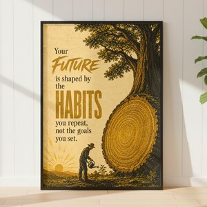 May include: A framed wall art print featuring a sepia-toned illustration of a person watering a small plant near a large tree stump. The text reads: Your FUTURE is shaped by the HABITS you repeat, not the goals you set. The design uses gold and brown.