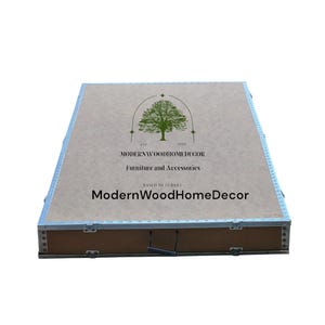 May include: A rectangular wooden storage box with metallic silver edges and a handle. The top surface features a green tree logo, the text EST 1999, MODERNWOODHOMEDECOR, Furniture and Accessories, BASED IN TURKEY, and ModernWoodHomeDecor.